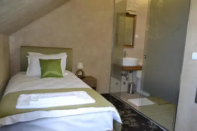 a bedroom with a bed and a bathroom with a sink at Garni Hotel Chicha - Winery ŠKRBIĆ in Belgrade