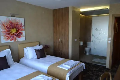 a hotel room with two beds and a bathroom at Garni Hotel Chicha - Winery ŠKRBIĆ in Belgrade