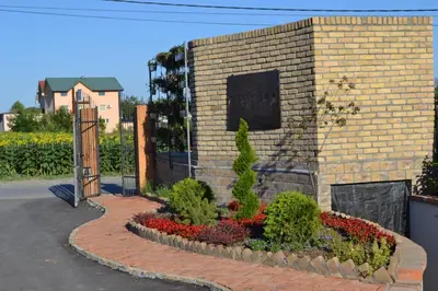 a brick building with a gate and a bunch of flowers at Garni Hotel Chicha - Winery ŠKRBIĆ in Belgrade