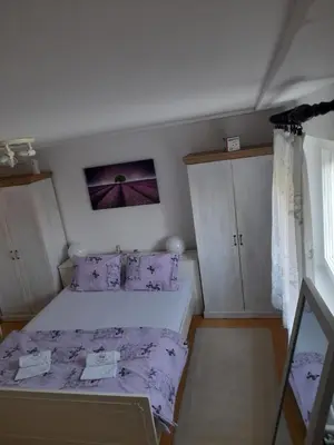 a bedroom with a bed with purple sheets and pillows at Apartment Aqua Royal in Arandjelovac