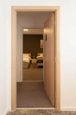 a door leading to a bedroom with two beds at Chess Apartments in Belgrade