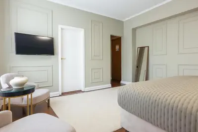 a bedroom with a bed and a tv on a wall at Hotel Majestic in Belgrade