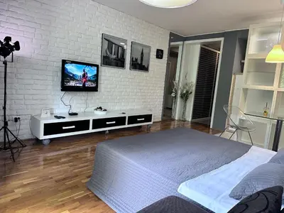 a bedroom with a tv on a white brick wall at BASE Accommodation Apartments in Belgrade