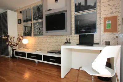 a living room with a white desk and a tv at BASE Accommodation Apartments in Belgrade