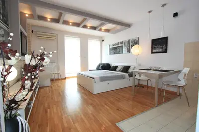 a living room with a bed and a table in it at BASE Accommodation Apartments in Belgrade