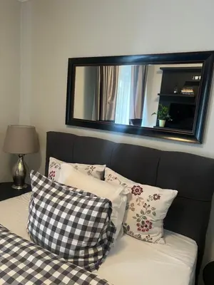 a bed with pillows and a mirror on the wall at Apartment D-22 in Belgrade