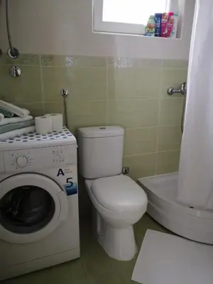 a bathroom with a toilet and a washing machine at Airport apartment T&T in Surčin