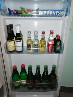 a refrigerator filled with lots of bottles of soda at Airport apartment T&T in Surčin
