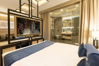a bedroom with a bed and a tv and a bathroom at Eden Luxury Suites Terazije in Belgrade