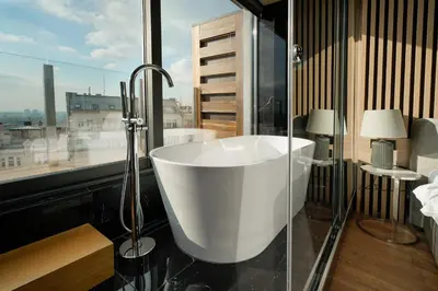 a bath tub in a bathroom with a window at Eden Luxury Suites Terazije in Belgrade