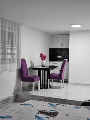 a dining room with purple chairs and a table at Studio Dana in Arandjelovac