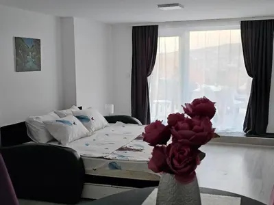 a room with a bed and a table with roses at Studio Dana in Arandjelovac