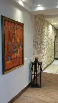a painting hanging on a wall next to a table at Genex Apartment in Belgrade