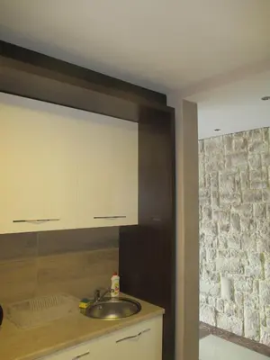 a kitchen with a sink and a stone wall at Genex Apartment in Belgrade