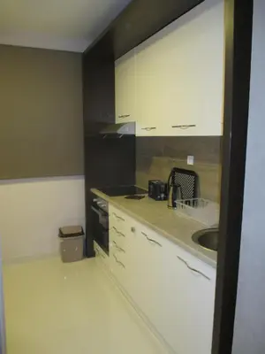 a kitchen with white cabinets and a sink at Genex Apartment in Belgrade