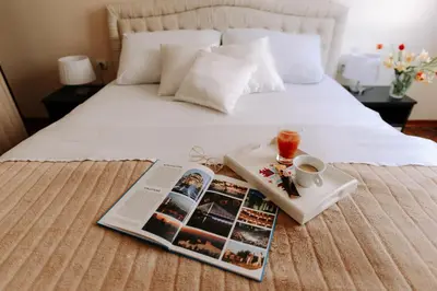 a magazine and a tray of food on a bed at Apartman Milenijum in Belgrade