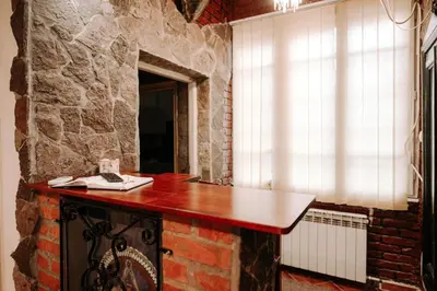 a brick wall with a table in a room with a window at Apartman Milenijum in Belgrade