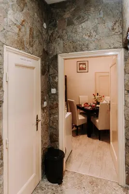 a door leading into a dining room with a stone wall at Apartman Milenijum in Belgrade