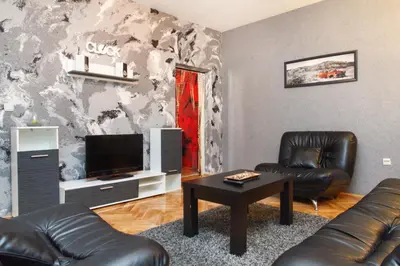 a living room with two leather chairs and a television at Apartment Aleksandar in Belgrade