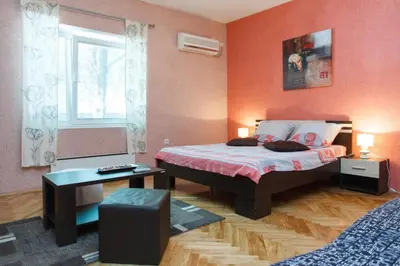 a small bedroom with a bed and a window at Apartment Aleksandar in Belgrade