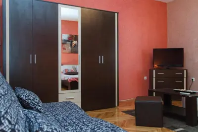 a bedroom with a large wardrobe and a television at Apartment Aleksandar in Belgrade