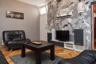 a living room with a couch and a table and a tv at Apartment Aleksandar in Belgrade