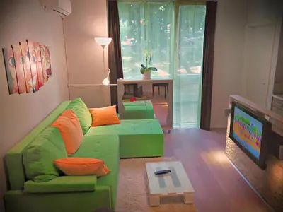 a living room with a green couch and a tv at Banshill Apartment in Belgrade