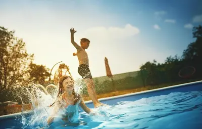a boy and a girl playing in a swimming pool at Laguna Platz in Sremski Karlovci