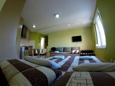 two beds in a room with a living room at Apartments Popovic in Belgrade