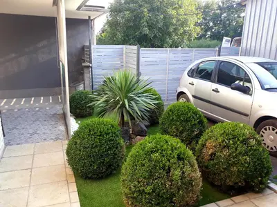 a yard with a car parked next to a fence at Apartments Popovic in Belgrade