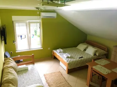 a small room with a bed and a window at Apartments Popovic in Belgrade