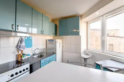 a kitchen with green cabinets and a white counter top at Central Monument Apartment Bojkovic in Belgrade