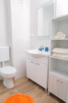 a bathroom with a white sink and a toilet at Apartment Koral in Ruma