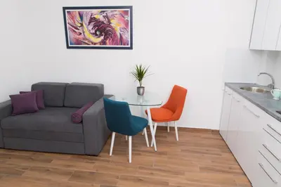 a living room with a couch and a table and chairs at Apartment Koral in Ruma