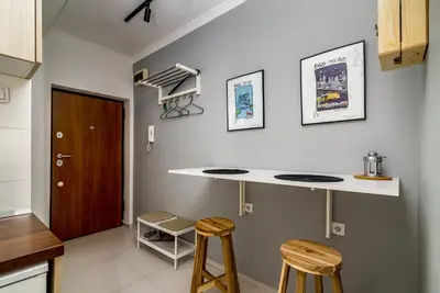 a kitchen with a white counter and two stools at Cozy Central Studio - Steps from Knez Mihailova in Belgrade