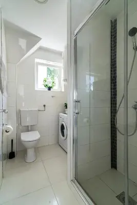 a bathroom with a toilet and a glass shower at Cozy Central Studio - Steps from Knez Mihailova in Belgrade