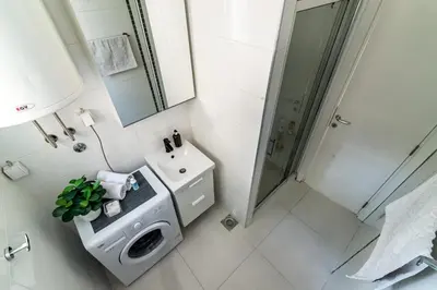 a white bathroom with a sink and a shower at Cozy Central Studio - Steps from Knez Mihailova in Belgrade