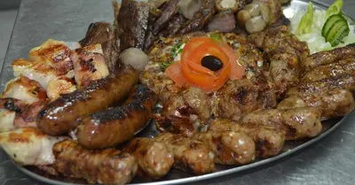 a plate of food with sausage and other foods at Hotel Centar Balasevic in Belgrade