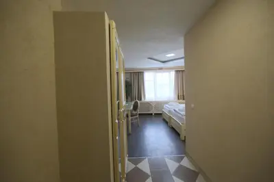 a hallway to a room with a bed and a window at Hotel Centar Balasevic in Belgrade