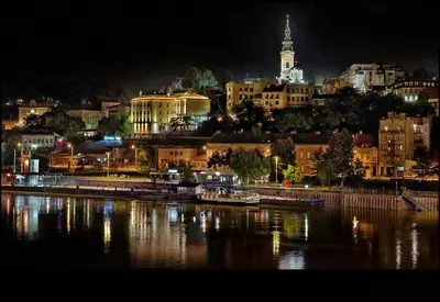 a city lit up at night with a river and buildings at Hotel Centar Balasevic in Belgrade