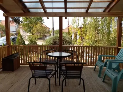 a patio with a table and chairs on a deck at Apartman Otvoreno polje in Arandjelovac