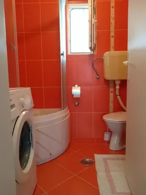 a bathroom with a washing machine and a toilet at Apartman Otvoreno polje in Arandjelovac