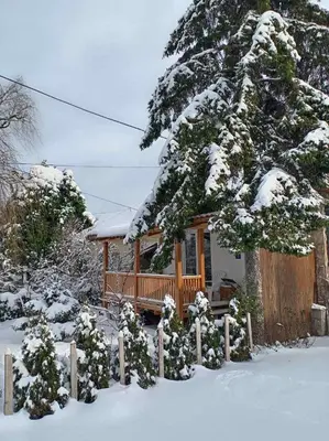 a house with a porch in the snow at Apartman Otvoreno polje in Arandjelovac