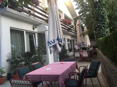 a table and chairs with a table and an umbrella at Guest House Major in Arandjelovac