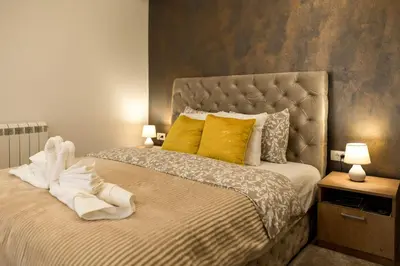a bedroom with a large bed with yellow pillows at President 034 in Arandjelovac