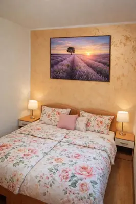 a bedroom with a bed with a painting on the wall at President 034 in Arandjelovac