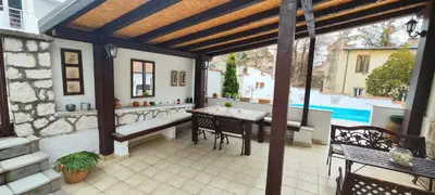 an outdoor patio with a table and chairs and a bench at Vila Mila in Arandjelovac