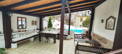 a patio with a table and chairs and a pool at Vila Mila in Arandjelovac