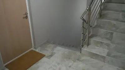 a hallway with a staircase with marble floors and a door at Flat Kosutnjak 9 in Belgrade
