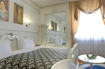 a bedroom with a large bed and a large mirror at Queen's Astoria Design Hotel in Belgrade